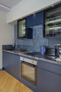 a kitchen with blue cabinets and a sink at Signature Apartments in Blackpool