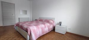 Habitación blanca con cama y mesita de noche en Alloggio TOBIA en Biella