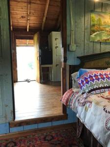 een slaapkamer met een bed en een deur naar een keuken bij The Hunter Cabin at Sky Hollow in Rochester