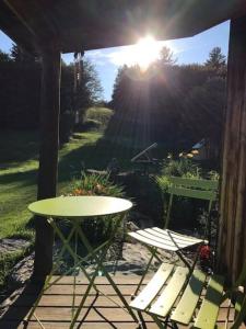 een tafel en twee stoelen op een patio met de zon bij The Hunter Cabin at Sky Hollow in Rochester
