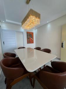 una sala conferenze con tavolo bianco e sedie marroni di Mar & Sol a Guarujá