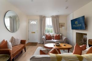 een woonkamer met banken en een tafel bij Beautiful cottage style 3-bed By Valore Property Services in Loughton
