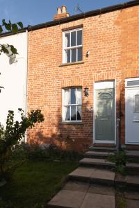 a brick house with a blue door and windows at Beautiful cottage style 3-bed By Valore Property Services in Loughton