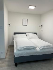 una camera con letto e lenzuola bianche di Apartman a Cheb