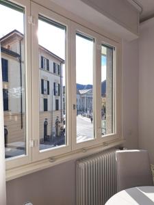 a room with three windows and a radiator at The window on the theatre and the cathedral - Luxury apartment in Como