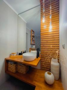 La salle de bains est pourvue d'un lavabo et d'un grand miroir. dans l'établissement Mavromata's Cozy Apartment, à Triovasálos