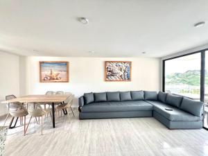 uma sala de estar com um sofá azul e uma mesa em Caribbean Venture Apto 901- Rodadero, Santa Marta em Santa Marta