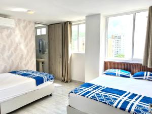 2 camas en una habitación con 2 ventanas en Caribbean Venture Apto 901- Rodadero, Santa Marta, en Santa Marta