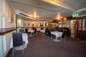 a restaurant with tables and chairs and a bar at Best Western Cattle City Motor Inn in Rockhampton