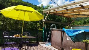 an umbrella and a table and chairs under a canopy at Abri de jardin aménagé, chambre Camping Glamour in Lalaye