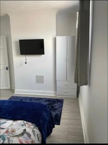 um quarto com uma cama e uma televisão na parede em Samarlon Home Saxton em Gillingham