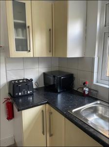 a kitchen counter with a microwave and a sink at Samarlon Home Saxton in Gillingham