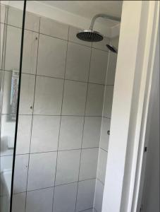 a shower in a bathroom with a white tile wall at Samarlon Home Saxton in Gillingham