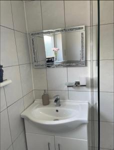 a white bathroom with a sink and a mirror at Samarlon Home Saxton in Gillingham