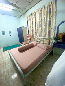 a hospital room with a bed with pink sheets at Ramizu Homestay Pokok Sena in Pokok Sena