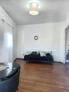 ein Wohnzimmer mit einem Bett in einem weißen Zimmer in der Unterkunft Apartamento esq Rambla y centrico in Montevideo