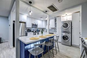 フェニックスにあるModern Home-Downtown-3 Bedroom- King Bedの白いキャビネットとバースツール付きの青い島のあるキッチンが備わります。