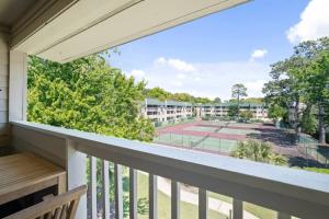 a balcony with a tennis court at Peaceful Treetop Condo - 2br/2ba in Hilton Head Island