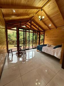 a bedroom in a wooden house with a bed and a table at Chalet Amauleza in San Gerardo de Dota