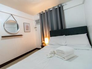 a bedroom with a white bed with a mirror at Whitehaus BnB in Bais