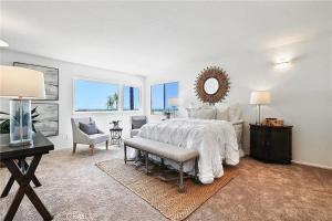 Habitación blanca con cama, escritorio y espejo. en Beachfront 3 Bedroom 3 Bath In Seal Beal, Ca, en Seal Beach