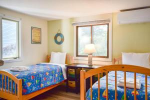 1 dormitorio con 2 camas y mesa con lámpara en Lake House in Centerville with Private Water Access, en Barnstable