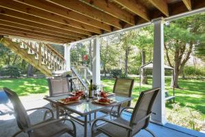 un patio con mesa y sillas en un porche en Lake House in Centerville with Private Water Access, en Barnstable