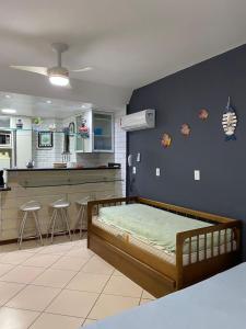 Un dormitorio con una cama y una cocina. en Arraial do Cabo, Loft Visão do Paraíso, en Arraial do Cabo