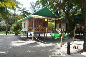 eine kleine Hütte mit einer Hängematte und einem Haus in der Unterkunft Palm Beach Bungalow Resort in Koh Rong