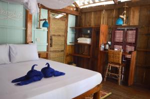 ein Schlafzimmer mit einem Bett mit zwei blauen Handtüchern darauf in der Unterkunft Palm Beach Bungalow Resort in Koh Rong + 37 Fotos