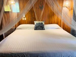 1 dormitorio con 1 cama grande y paredes de madera en Blue House, en Puerto Escondido