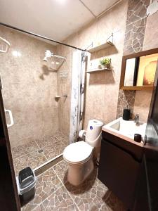 a bathroom with a toilet and a shower and a sink at Apartaestudio Encanto Pacífico in Cali +22 photos