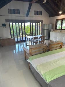 a room with two beds and a table and chairs at Vila Del Mare Beachfront Resort in Port Vila