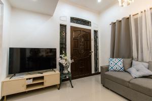 a living room with a flat screen tv and a couch at Whitehaus BnB in Bais