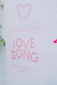 a sign that says i love song butoke hotel camu at Love Song Boutique Hotel in Canggu