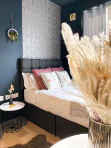 Schlafzimmer mit einem Bett mit einem schwarzen Kopfteil in der Unterkunft Holland Road Stays in London