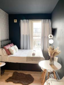 Schlafzimmer mit einem Bett, einem Fenster und einem Tisch in der Unterkunft Holland Road Stays in London