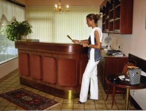 Una donna in piedi accanto a un bancone in una cucina di Pension & Apartments Ertl a Seeboden