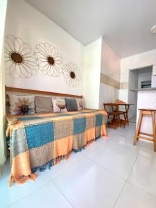 a bedroom with a large bed with flowers on the wall at Residencial Morro de São Paulo in Morro de São Paulo