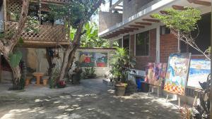 un espace extérieur avec des peintures sur le côté d'un bâtiment dans l'établissement Exedra de Galeria Cafe. Mindo- Ecuador, à Mindo