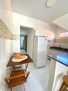 a kitchen with a table and a refrigerator at Residencial Morro de São Paulo in Morro de São Paulo