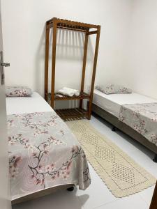 a room with two beds and a table with a bedskirts at Residencial Morro de São Paulo in Morro de São Paulo