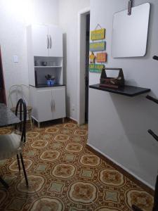Zimmer mit einer Küche mit einer Theke und einem Kühlschrank. in der Unterkunft Apartamento de frente a Praia, pé na areia com wi-fi LOFTJM com 01 vaga de garagem sujeita a disponibilidade in Santos