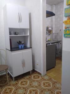 eine Küche mit weißen Schränken und einem Kühlschrank in der Unterkunft Apartamento de frente a Praia, pé na areia com wi-fi LOFTJM com 01 vaga de garagem sujeita a disponibilidade in Santos