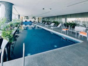 a large pool in a building with chairs and tables at On Paseo de la Reforma, great location, luxurious, pool, gym, AC in Mexico City