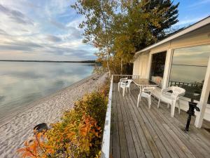 un porche con 2 sillas y una mesa en una casa en NTJ Moose Lake Cabin, en Bonnyville