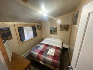 a small bedroom with a bed in a tiny house at NTJ Moose Lake Cabin in Bonnyville