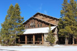 una gran casa de madera con árboles delante de ella en Large home less than 5 miles to Yellowstone North Entrance, Sleeps up to 8 en Gardiner