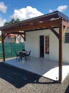 a pavilion with a table and chairs on a patio at Gite des îles in Sainte-Rose