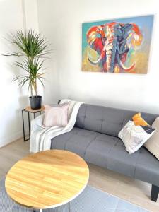 a living room with a gray couch and an elephant painting at Chic Retreat: 2-Bed 1 Ensuite Oasis in Birmingham
